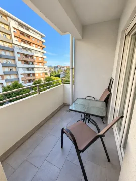 Small bright balcony with seating furniture and a view of buildings. - image 5