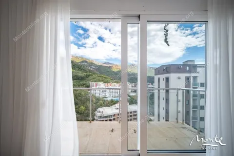 View from the balcony overlooking surrounding buildings, hills, and blue sky. - image 22