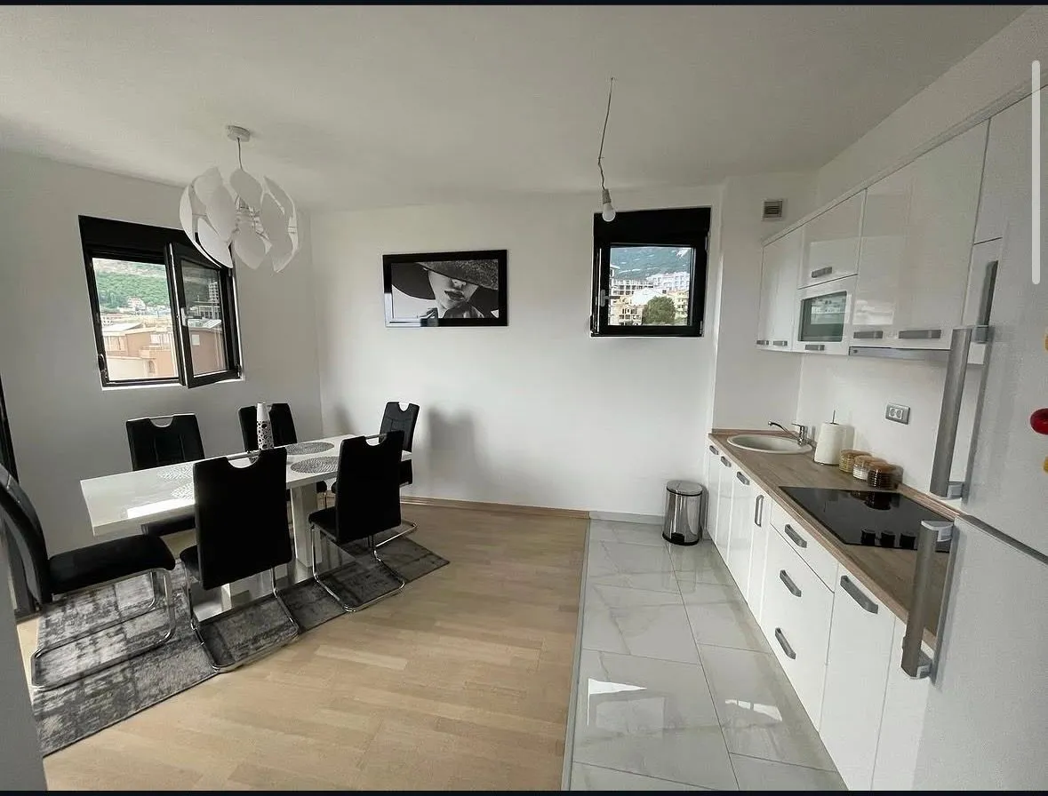 Modern kitchen with dining area and white cabinets.