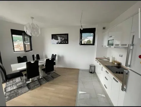 Modern kitchen with dining area and white cabinets. - image 5
