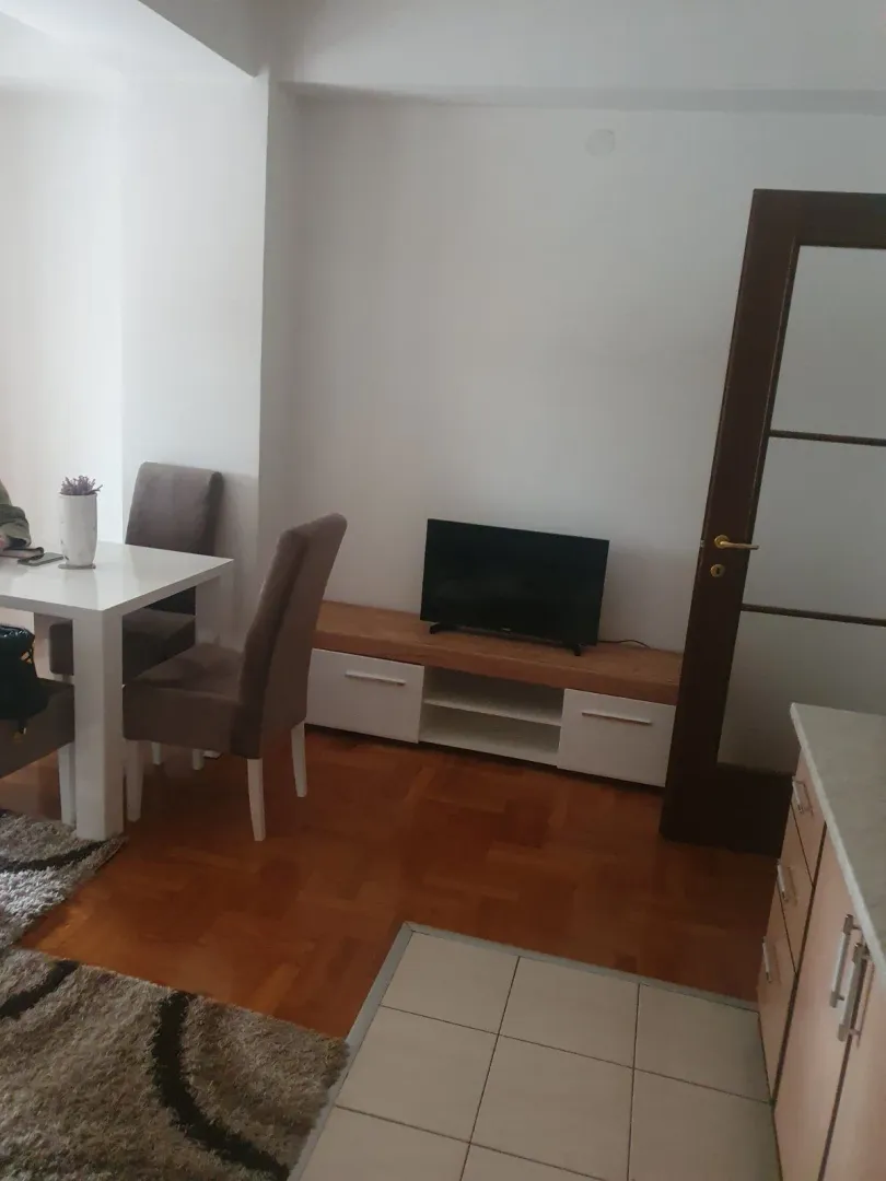 Bright living area with a dining table and a TV stand.