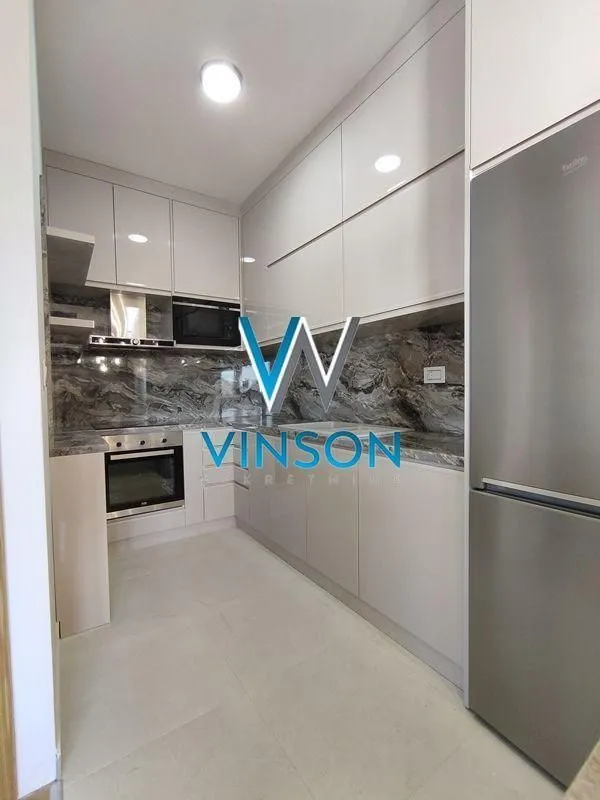 Modern kitchen with built-in appliances and a refrigerator.