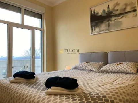 Furnished bedroom with a double bed and large balcony doors. - image 16