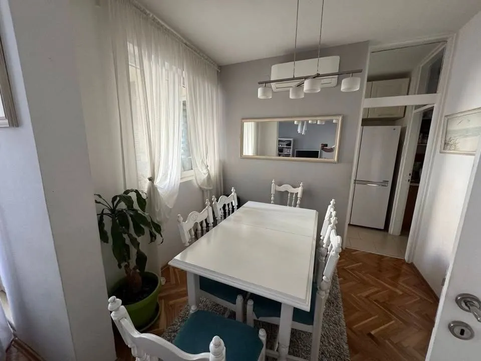 Trpezarija sa bijelim stolom i stolicama.