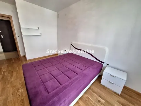 Nameštena spavaća soba sa bračnim krevetom i belim noćnim stočićem. - image 11