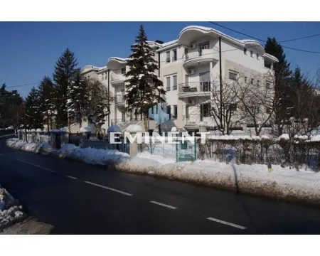 View of the exterior of the residential building with snow-covered surroundings and a street in the foreground. - image 11