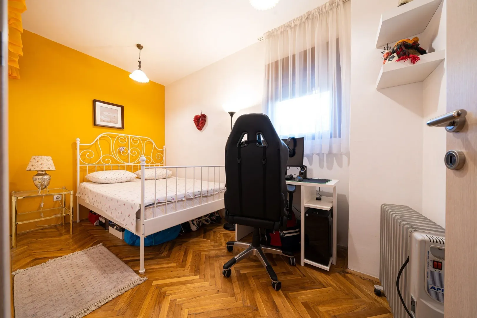 Furnished bedroom with a bed and a desk.