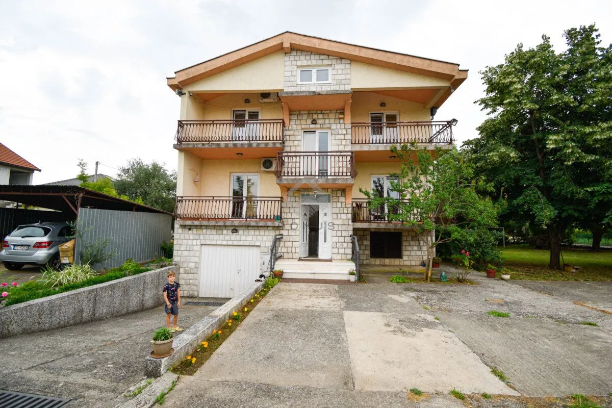 Front view of a multi-story house with a yard and garage.