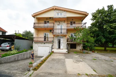 Front view of a multi-story house with a yard and garage. - image 2