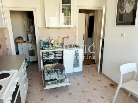 Kitchen with an open dishwasher and doorway leading to the hallway. - image 7