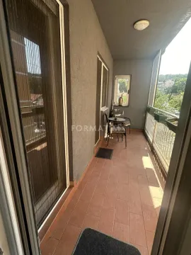 Covered balcony with ceramic tiles and outdoor seating. - image 3