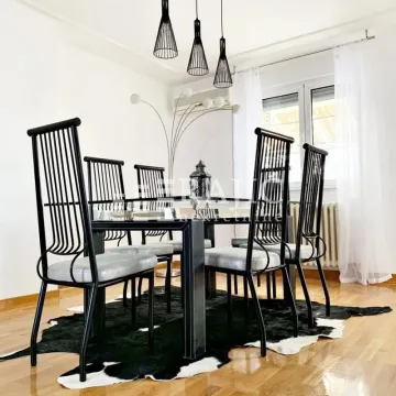 Dining room with a black table, chairs, and a faux-hide rug. - image 8
