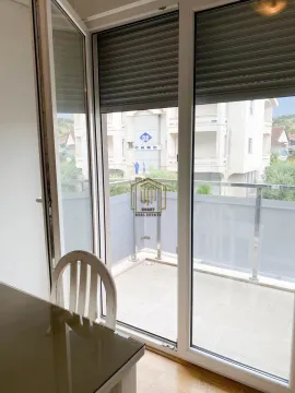 View through the balcony door onto the terrace and surrounding buildings. - image 8
