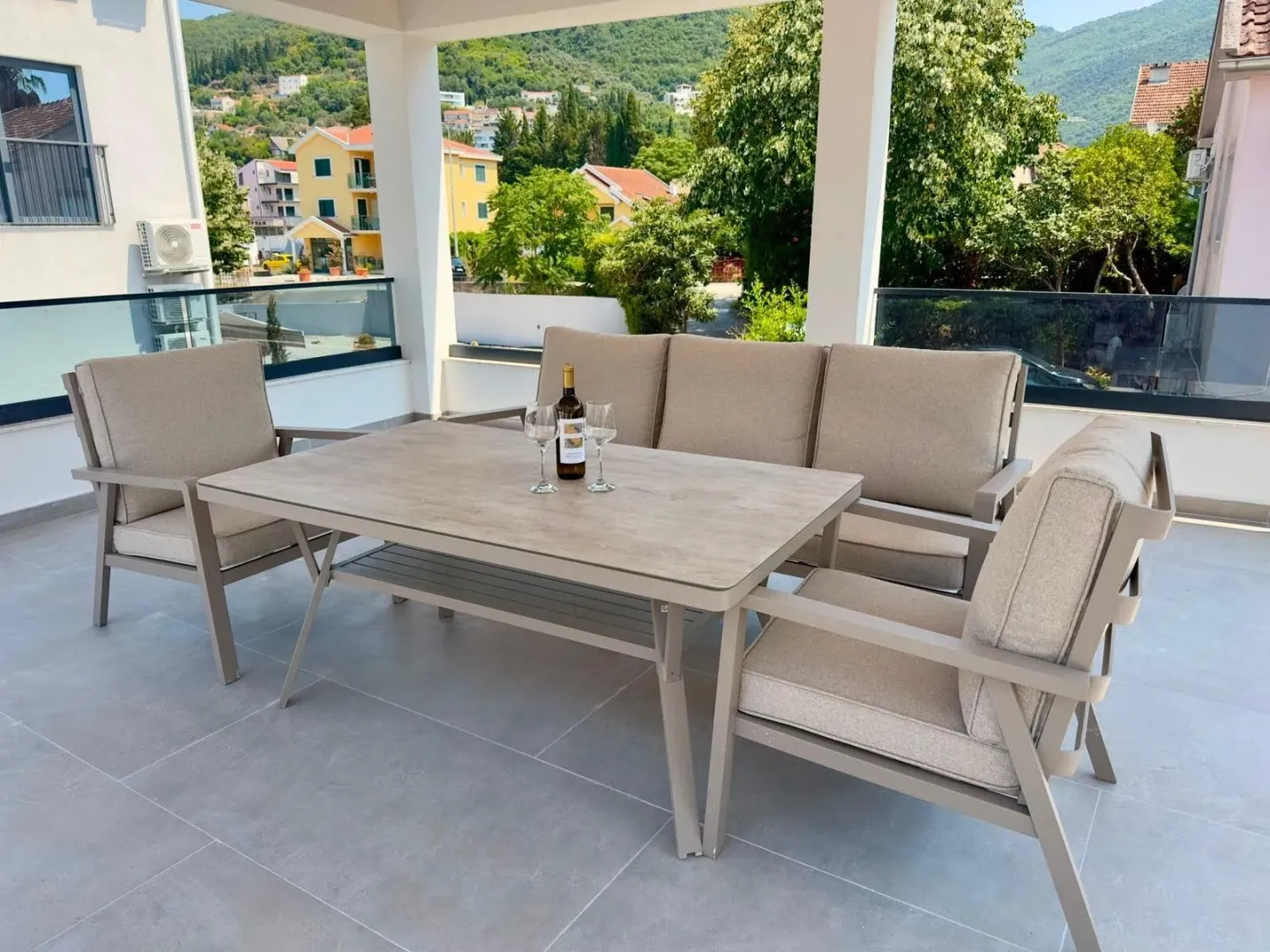 Furnished covered terrace with seating set and surrounding view.