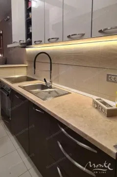 A view of the kitchen unit with a sink, countertop, and upper cabinets. - image 8