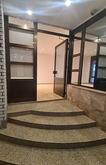 Entrance to the commercial space with steps and glass storefront.