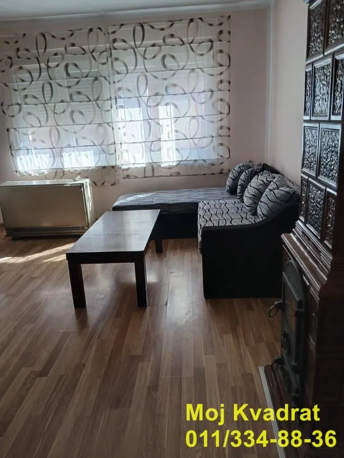 Living room with a sectional sofa, coffee table, and wood-burning stove.