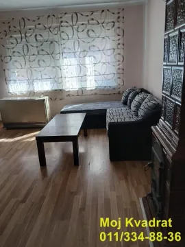 Living room with a sectional sofa, coffee table, and wood-burning stove. - image 2
