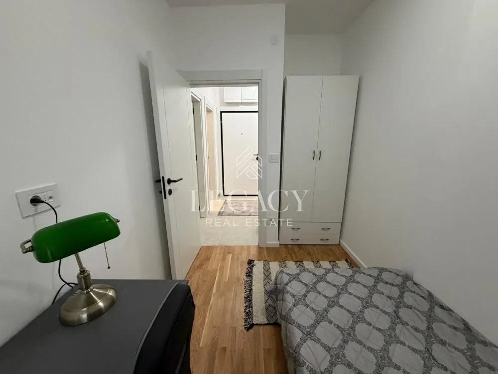 Small furnished bedroom with a bed and wardrobe.