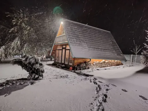 Pogled na drvenu vikendicu noću pod snegom. - image 15