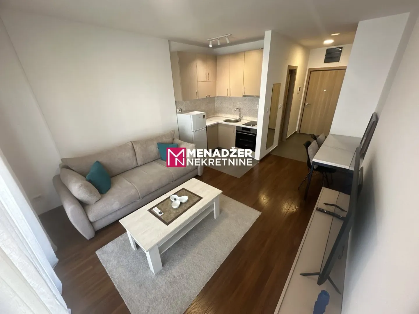 Living room connected to the kitchen and dining area in bright tones.