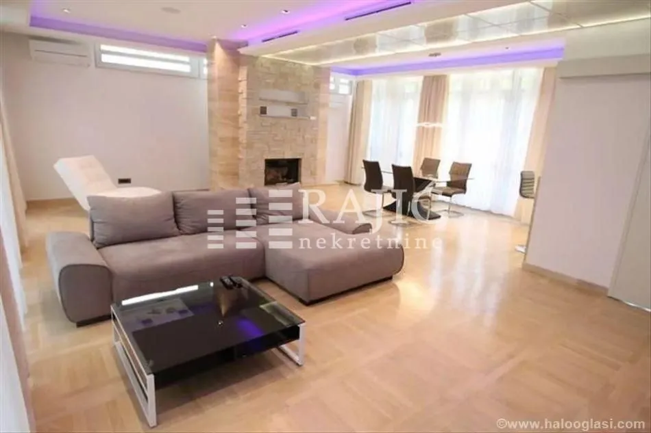 Spacious living room with a sofa and dining area in the background.