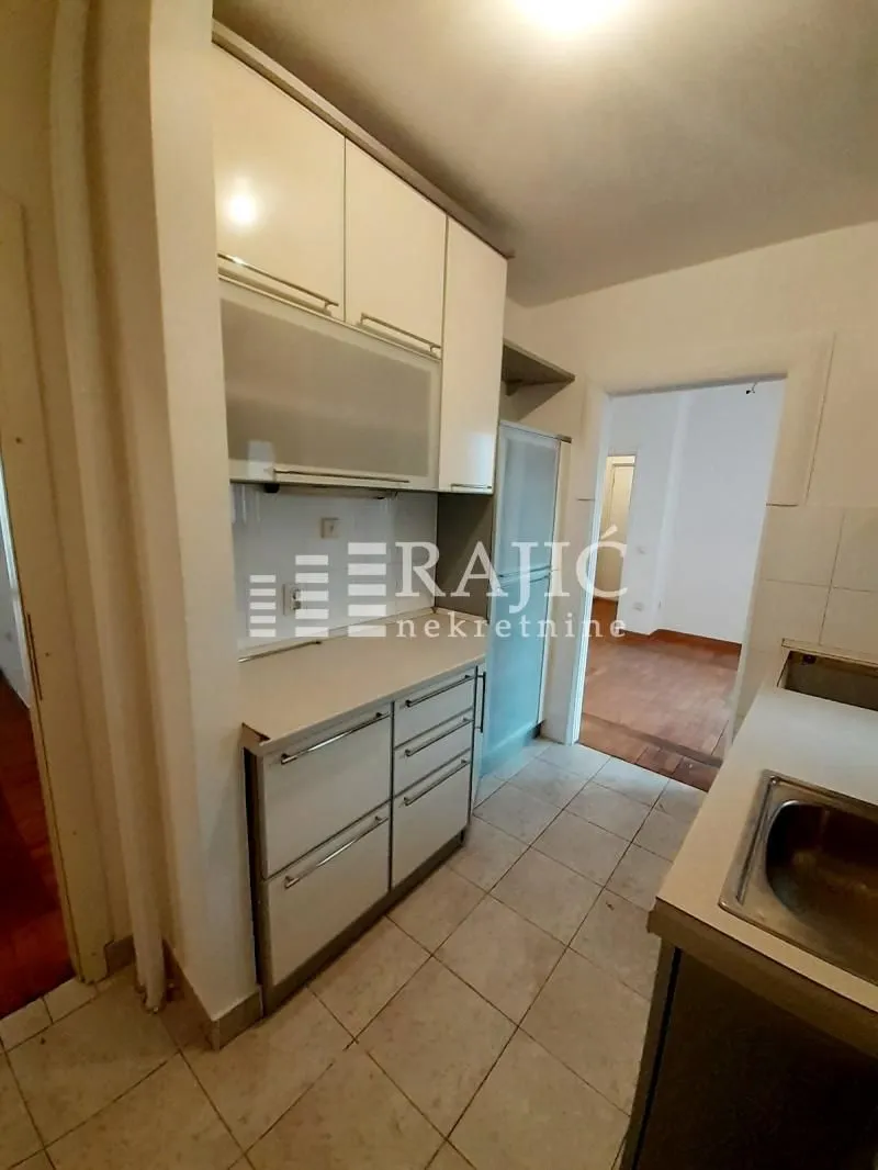 Small kitchen with white cabinets and a sink.