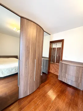 Bedroom with a large wooden wardrobe, bed, and wooden flooring. - image 3