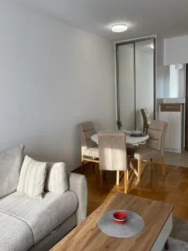 Living room with a sofa, dining table, and parquet flooring. - image 9