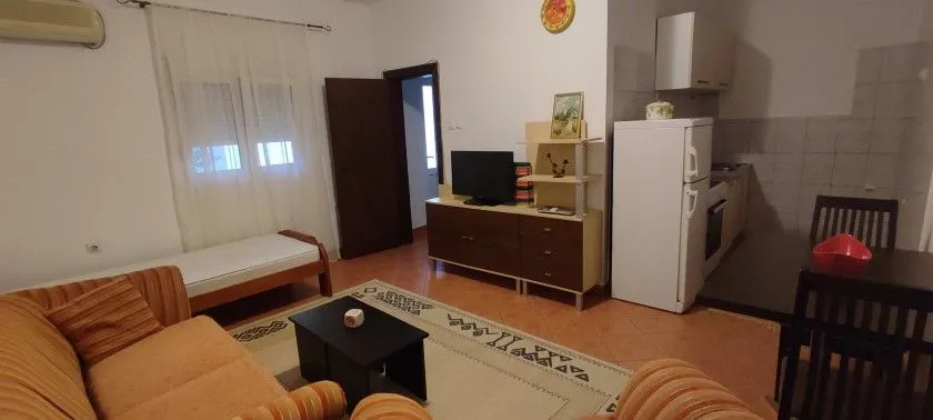 Dnevni boravak sa garniturom, TV-om i trpezarijskim dijelom.