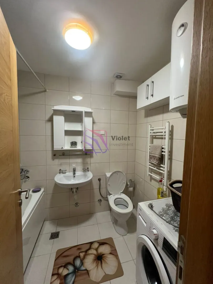 Kompaktno kupatilo sa kadom, umivaonikom, WC šoljom i veš mašinom.