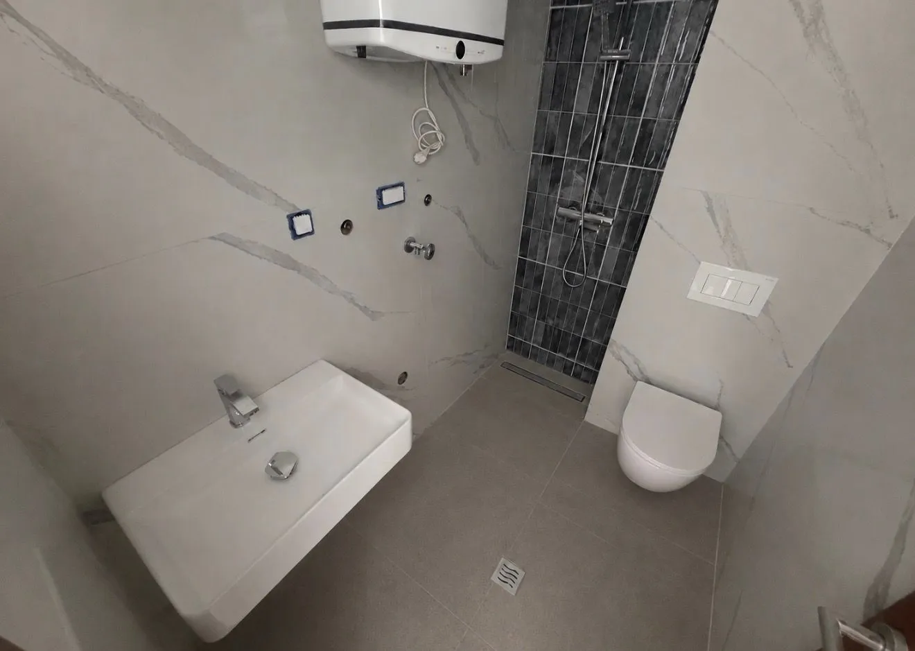 Novoopremljeno kupatilo sa umivaonikom, WC šoljom i tuš kabinom.