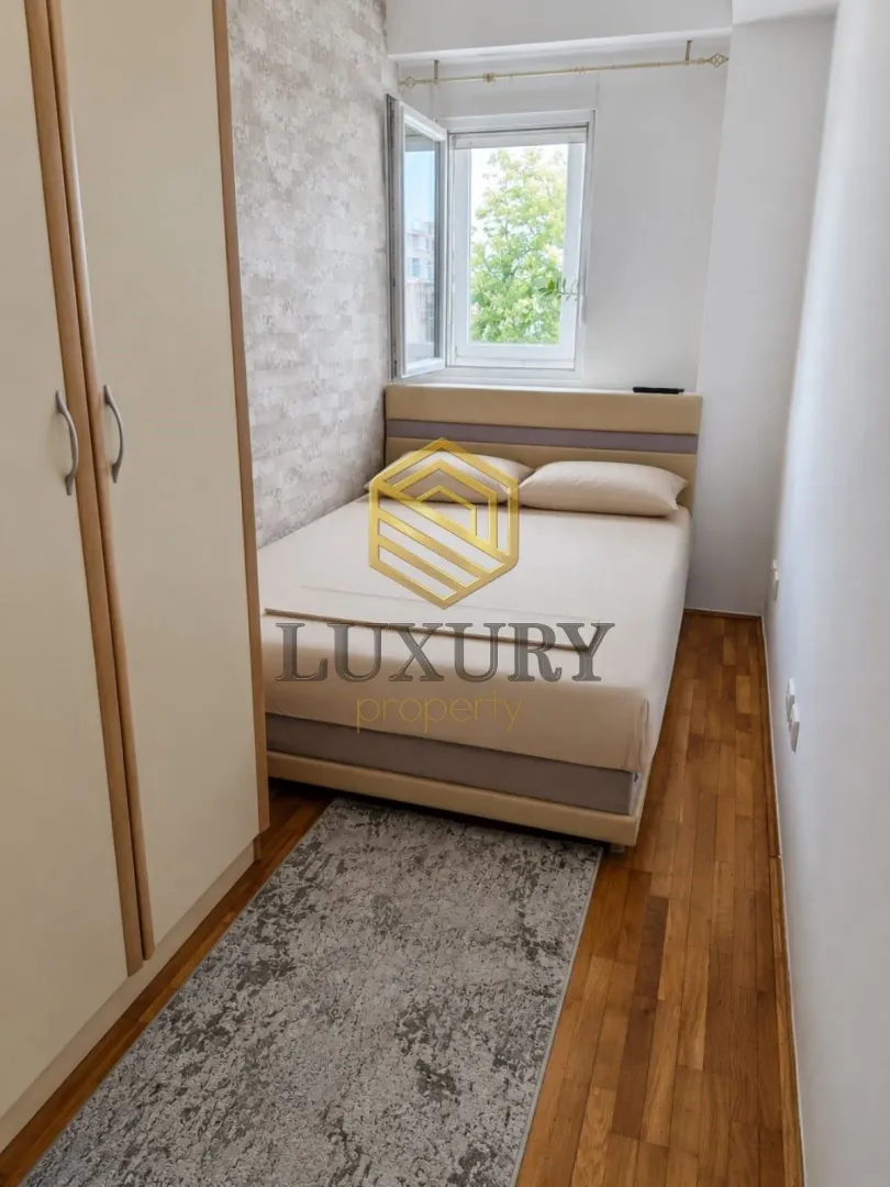 Small bedroom with a double bed, wardrobe, and wooden flooring.