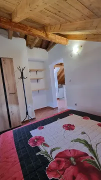 Spavaća soba sa krevetom, drvenim plafonom i ormarom. - image 8