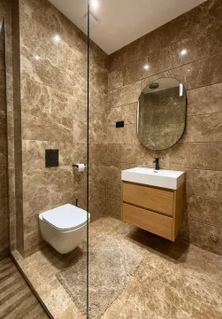Moderne kupatilo sa tuš kabinom, umivaonikom i WC šoljom obloženo mermernim pločicama. - image 7