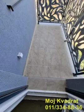 Pogled na manji popločani balkon sa ukrasnom metalnom ogradom. - image 10