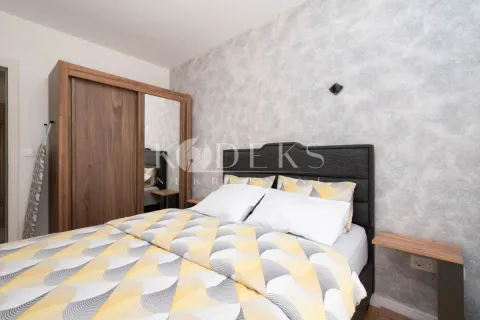 A bedroom with a double bed, a wooden wardrobe with a mirror, and wallpaper on the wall. - image 5