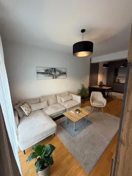 Living room with a sofa, coffee table, and rug, overlooking the dining area. - image 3