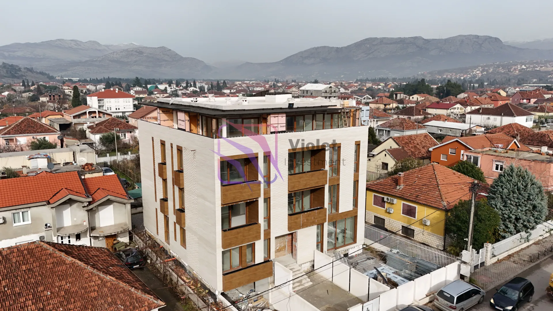 Pogled iz vazduha na novu zgradu u izgradnji okruženu gradskim naseljem.