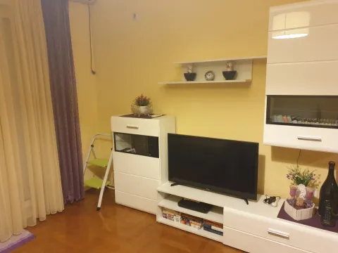 Dnevna soba sa televizorom, bijelim namještajem i žutim zidovima. - image 2