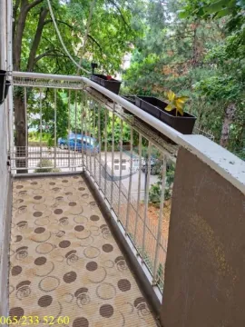 Manji balkon sa metalnom ogradom i pogledom na zelenilo i ulicu. - image 10