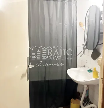 Small bathroom with a sink, mirror, and shower. - image 8
