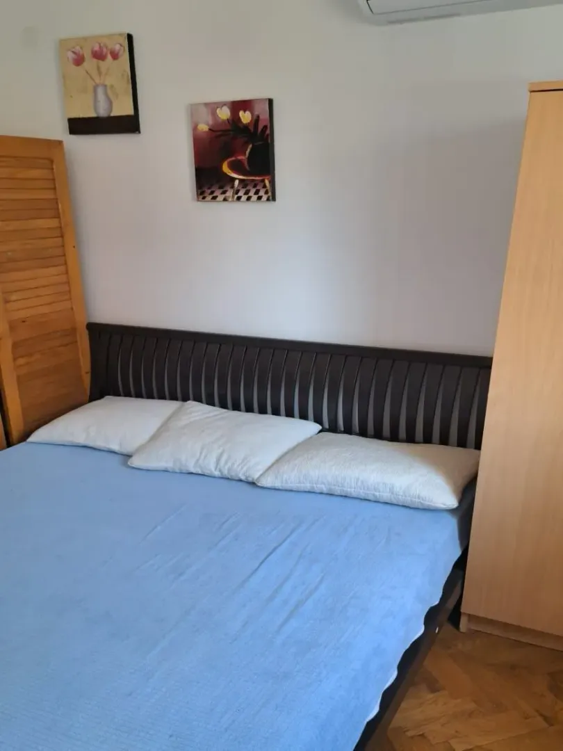 Furnished bedroom with a double bed, wardrobe, and wall art.