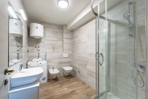 Moderno opremljeno kupatilo sa tuš kabinom, umivaonikom i veš mašinom. - image 13