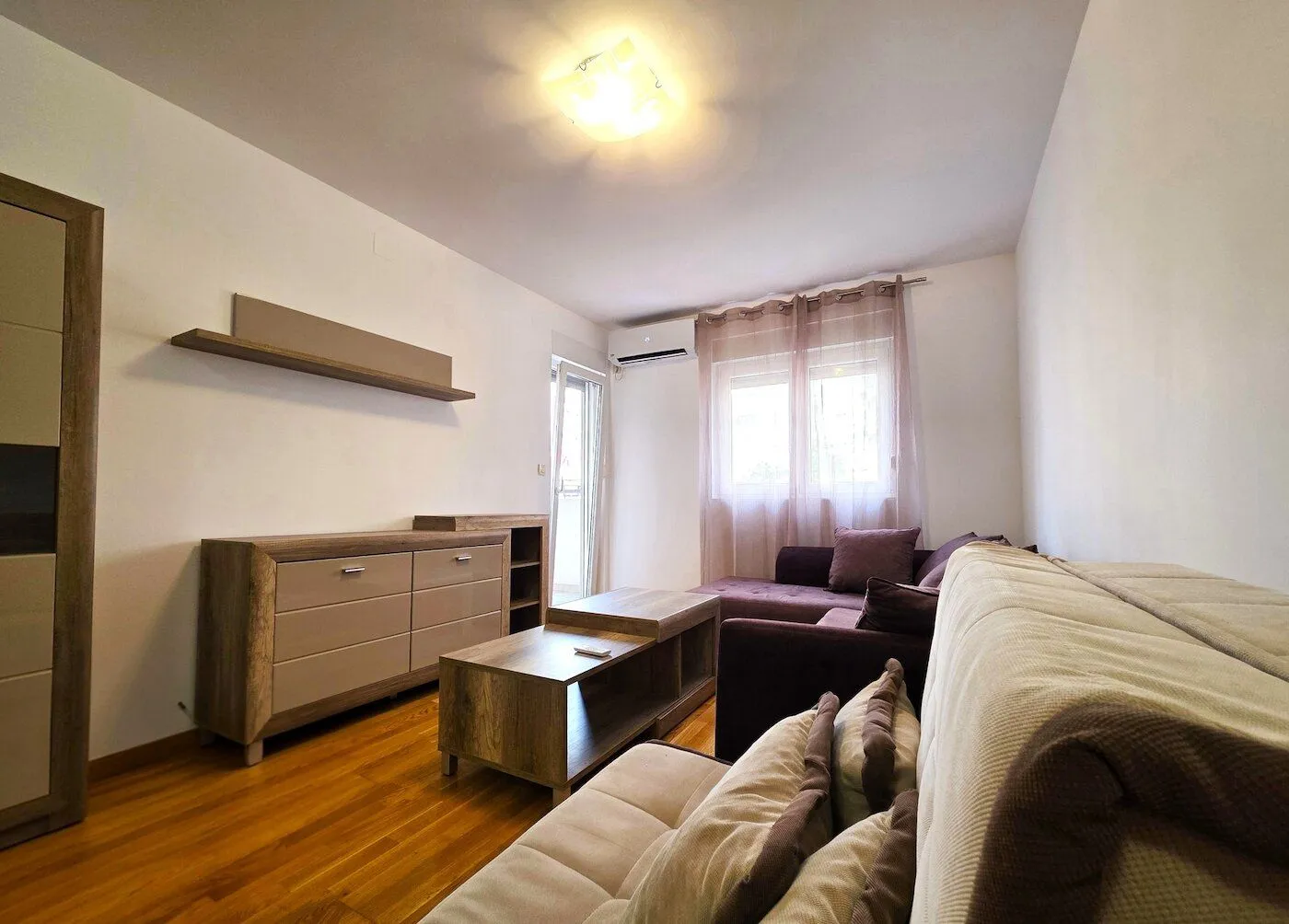 Living room with a sofa set, wooden dresser, and coffee table.