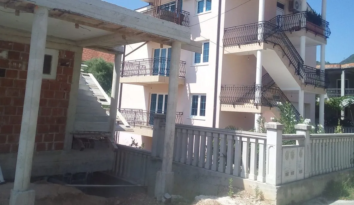 Exterior of a multi-story building with a concrete structure in the foreground.