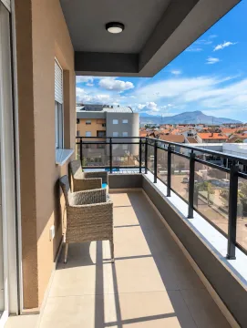 Covered balcony with seating furniture and a view of the surroundings. - image 3