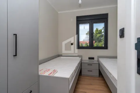 Small bedroom with two single beds, a wardrobe, and a window. - image 6