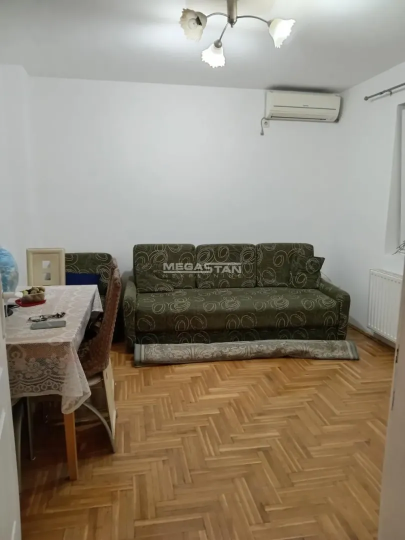 Dnevna soba sa garniturom i trpezarijskim stolom.