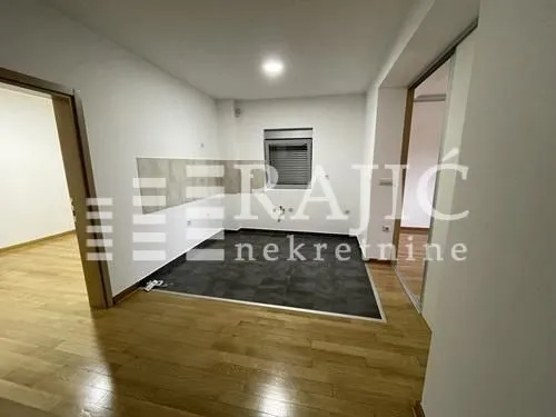 Empty kitchen with tiles and parquet flooring.